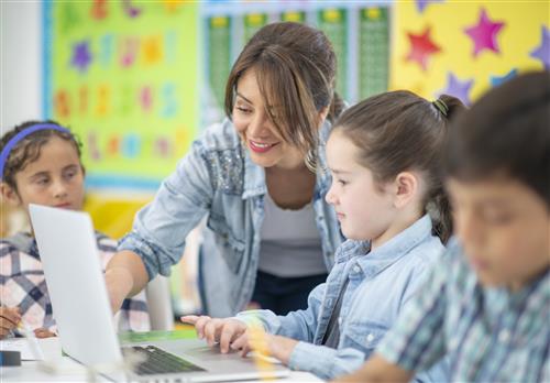 teacher teaching kids on computer