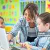  teacher helping student on computer