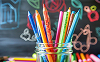 school supplies in front of a chalk board